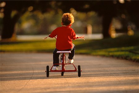 Back View of Boy Riding Tricycle Outdoors Stock Photo - Rights-Managed, Code: 700-00045867