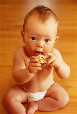 Portrait of Baby Holding Building Block to Mouth Stock Photo - Rights-Managed, Code: 700-00046728