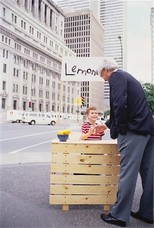 sell lemonade - Boy with Lemonade Stand on Street Serving Businessman Stock Photo - Rights-Managed, Code: 700-00047050