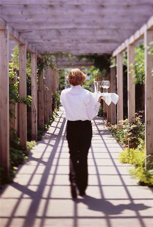 resort service - Back View of Waitress Carring Tray through Garden Walkway Stock Photo - Rights-Managed, Code: 700-00047132