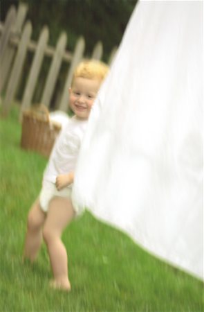 photos of white sheets on a clothes line - Child Playing with Laundry on Clothesline Stock Photo - Rights-Managed, Code: 700-00047318