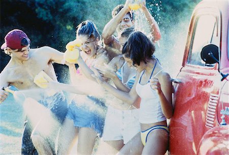 Group of Teenagers Having Water Fight while Washing Truck Stock Photo - Rights-Managed, Code: 700-00047324