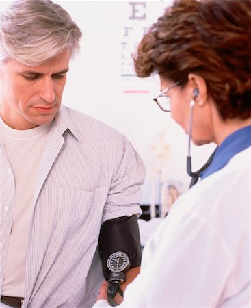 Female Doctor Taking Mature Male Patient's Blood Pressure Stock Photo - Rights-Managed, Code: 700-00040679