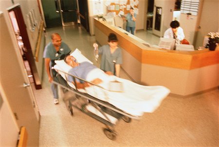 Doctors Wheeling Patient Through Hospital Foto de stock - Con derechos protegidos, Código: 700-00040997