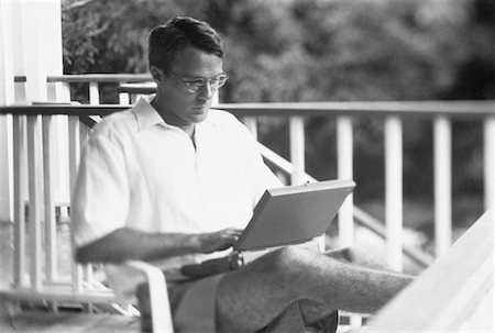 Man Using Laptop Computer in Chair on Porch Bahamas Stock Photo - Rights-Managed, Code: 700-00041374