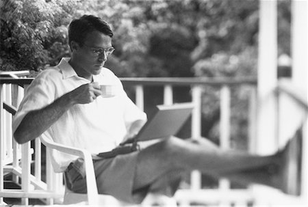 Man Using Laptop Computer in Chair on Porch Bahamas Stock Photo - Rights-Managed, Code: 700-00041375