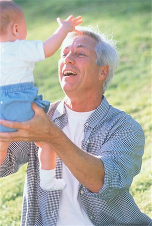 Grand-père Holding petit-enfant à l'extérieur Photographie de stock - Rights-Managed, Code: 700-00041483