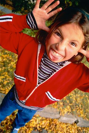 preteen girls tongue - Portrait of Young Girl Making Face Outdoors in Autumn Stock Photo - Rights-Managed, Code: 700-00041763