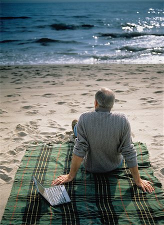 Back View of Mature Man on Beach With Laptop Computer Stock Photo - Rights-Managed, Code: 700-00042185