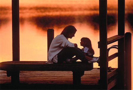 silhouette people sitting on a dock - Mother and Daughter on Dock at Sunset Foto de stock - Con derechos protegidos, Código: 700-00042254