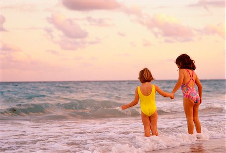 simsearch:700-00068959,k - Vue des filles en maillot de bain marcher en Surf sur la plage arrière Photographie de stock - Rights-Managed, Code: 700-00042353
