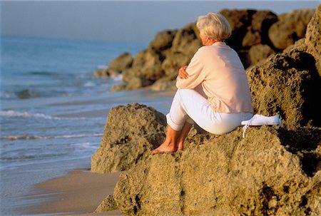 Femme mature assis sur les rochers près de la plage Photographie de stock - Rights-Managed, Code: 700-00042524