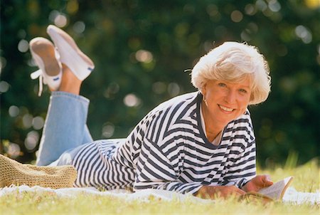 Portrait of Mature Woman Lying In Field with Book Stock Photo - Rights-Managed, Code: 700-00042526