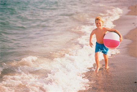 Boy in Swimewar, Running on Beach Carrying Beach Ball Stock Photo - Rights-Managed, Code: 700-00042520