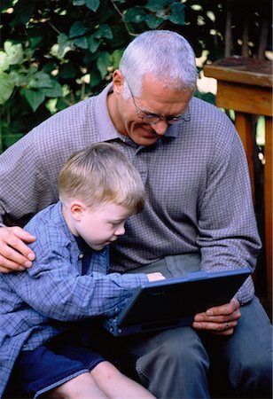 Grand-père et son petit-fils à l'extérieur à l'aide d'ordinateur portable Photographie de stock - Rights-Managed, Code: 700-00042755