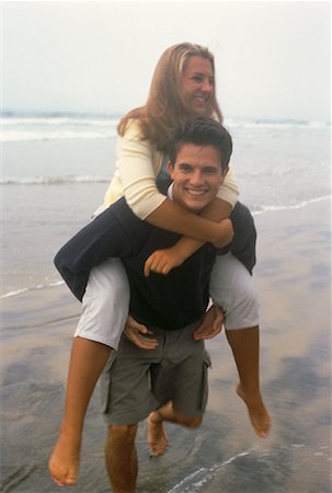 Teenage Boy Carrying Teenage Girl On Back on Beach Stock Photo - Rights-Managed, Code: 700-00054105