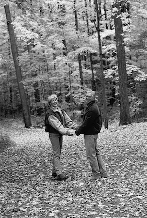 Couple d'âge mûr tenant par la main dans la forêt en automne Photographie de stock - Rights-Managed, Code: 700-00054155