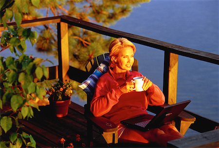 Mature Woman in Adirondack Chair On Deck with Laptop and Mug Stock Photo - Rights-Managed, Code: 700-00054940