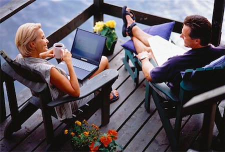 Mature Couple Sitting in Adirondack Chairs on Deck with Laptop Computer Stock Photo - Rights-Managed, Code: 700-00054942