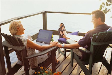 Mature Couple Sitting in Adirondack Chairs on Deck with Laptop Computer Stock Photo - Rights-Managed, Code: 700-00054943