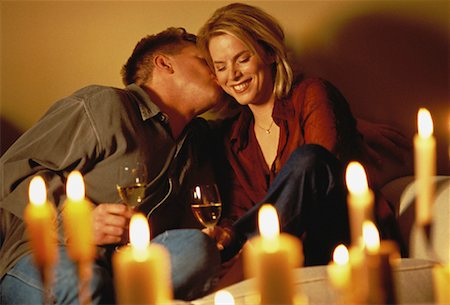 Couple Sitting on Sofa with Wine Glasses and Candlelight Foto de stock - Con derechos protegidos, Código: 700-00055601
