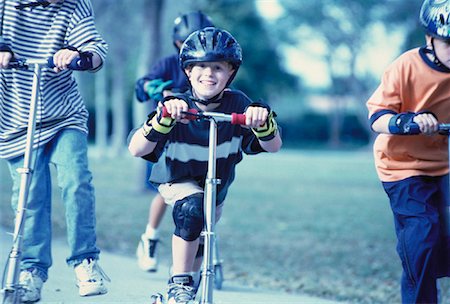 sports scooters - Group of Boys Riding Scooters on Sidewalk Foto de stock - Con derechos protegidos, Código: 700-00055631