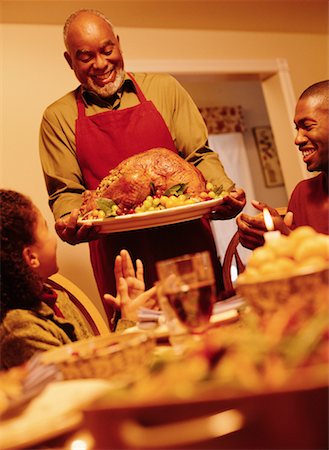 Grandfather Bringing Turkey to Thanksgiving Dinner Table Stock Photo - Rights-Managed, Code: 700-00055670