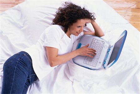 Overhead View of Woman Lying on Bed, Using Laptop Computer Foto de stock - Con derechos protegidos, Código: 700-00055685