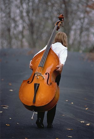 Back View of Girl Carrying Double Bass on Back Outdoors Fotografie stock - Rights-Managed, Codice: 700-00055744