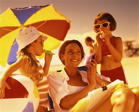 Mother Holding Cell Phone and Daughters Using Kazoos on Beach Stock Photo - Rights-Managed, Code: 700-00055981