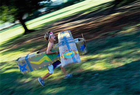 Boy Running through Field in Cardboard Airplane Stock Photo - Rights-Managed, Code: 700-00056152