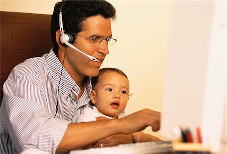 Father Using Telephone Headset And Computer with Baby on Lap Stock Photo - Rights-Managed, Code: 700-00057395
