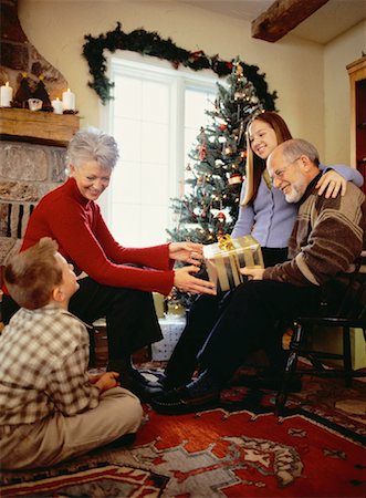 scambio dei regali di natale - Grandparents and Grandchildren Gathered Around Christmas Tree Fotografie stock - Rights-Managed, Codice: 700-00057509