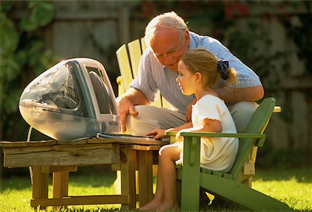 Grandfather and Granddaughter Using Computer Outdoors Stock Photo - Rights-Managed, Code: 700-00057994