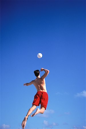 Back View of Male Volleyball Player Jumping to Hit Ball Stock Photo - Rights-Managed, Code: 700-00058077