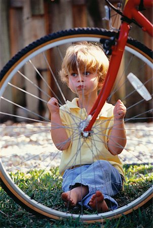 Portrait d'enfant assis derrière la roue de vélo Photographie de stock - Rights-Managed, Code: 700-00058073
