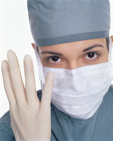 Portrait of Female Surgeon Putting on Rubber Glove Stock Photo - Rights-Managed, Code: 700-00058312