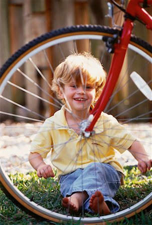 Portrait de garçon assis derrière le pneu de bicyclette, à l'extérieur Photographie de stock - Rights-Managed, Code: 700-00058580