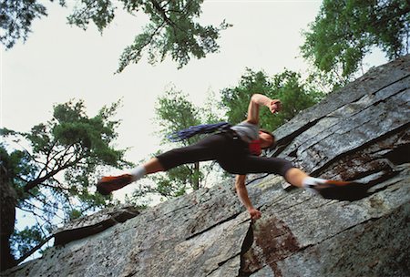 Looking Up at Male Rock Climber Jumping near Cliff Stock Photo - Rights-Managed, Code: 700-00058619