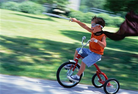 Boy Wearing Costume, Riding Tricycle Outdoors Foto de stock - Con derechos protegidos, Código: 700-00059105