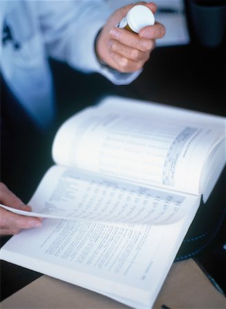 pill bottle in hand - Doctor's Hands Holding Pill Bottle and Book Stock Photo - Rights-Managed, Code: 700-00050982