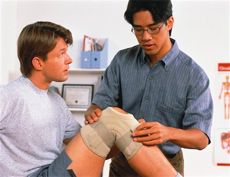 physio asian - Male Physiotherapist Exercising Male Patient's Knee Stock Photo - Rights-Managed, Code: 700-00051441