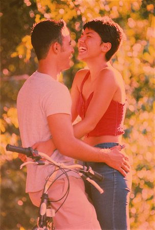 simsearch:700-00086310,k - Couple Leaning on Bicycle Embracing Outdoors Stock Photo - Rights-Managed, Code: 700-00051474