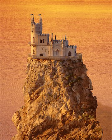 sécurité de la maison - Modifié la vue du château sur le rocher dans l'océan au coucher du soleil Photographie de stock - Rights-Managed, Code: 700-00051483