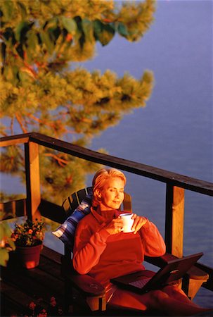 Mature Woman with Laptop Computer And Coffee Mug on Sundeck Stock Photo - Rights-Managed, Code: 700-00052504