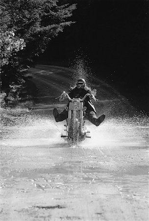 riding a bike funny pic - Biker Driving Motorcycle through Puddle on Road, Ontario, Canada Stock Photo - Rights-Managed, Code: 700-00053525