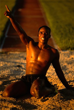 Ecstatic Man in Sand Pit after Long Jump Stock Photo - Rights-Managed, Code: 700-00053548