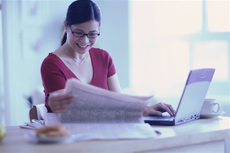 simsearch:700-00062758,k - Woman Sitting at Desk with Laptop Computer and Newspaper Stock Photo - Rights-Managed, Code: 700-00064043