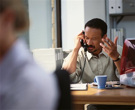 Businessman Sitting at Desk Using Telephone Foto de stock - Con derechos protegidos, Código: 700-00065145