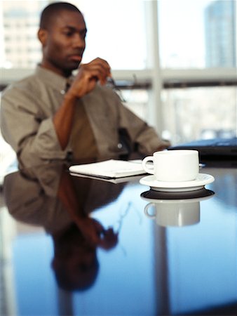 simsearch:700-00367646,k - Businessman Sitting at Table Holding Eyeglasses Stock Photo - Rights-Managed, Code: 700-00065402